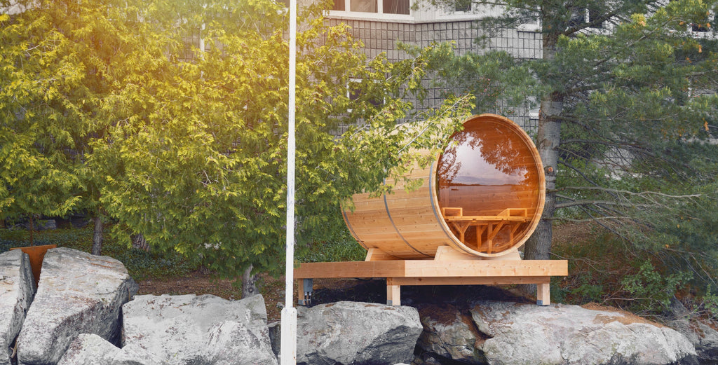 A premium cedar barrel sauna amongst the tree line on the lake.