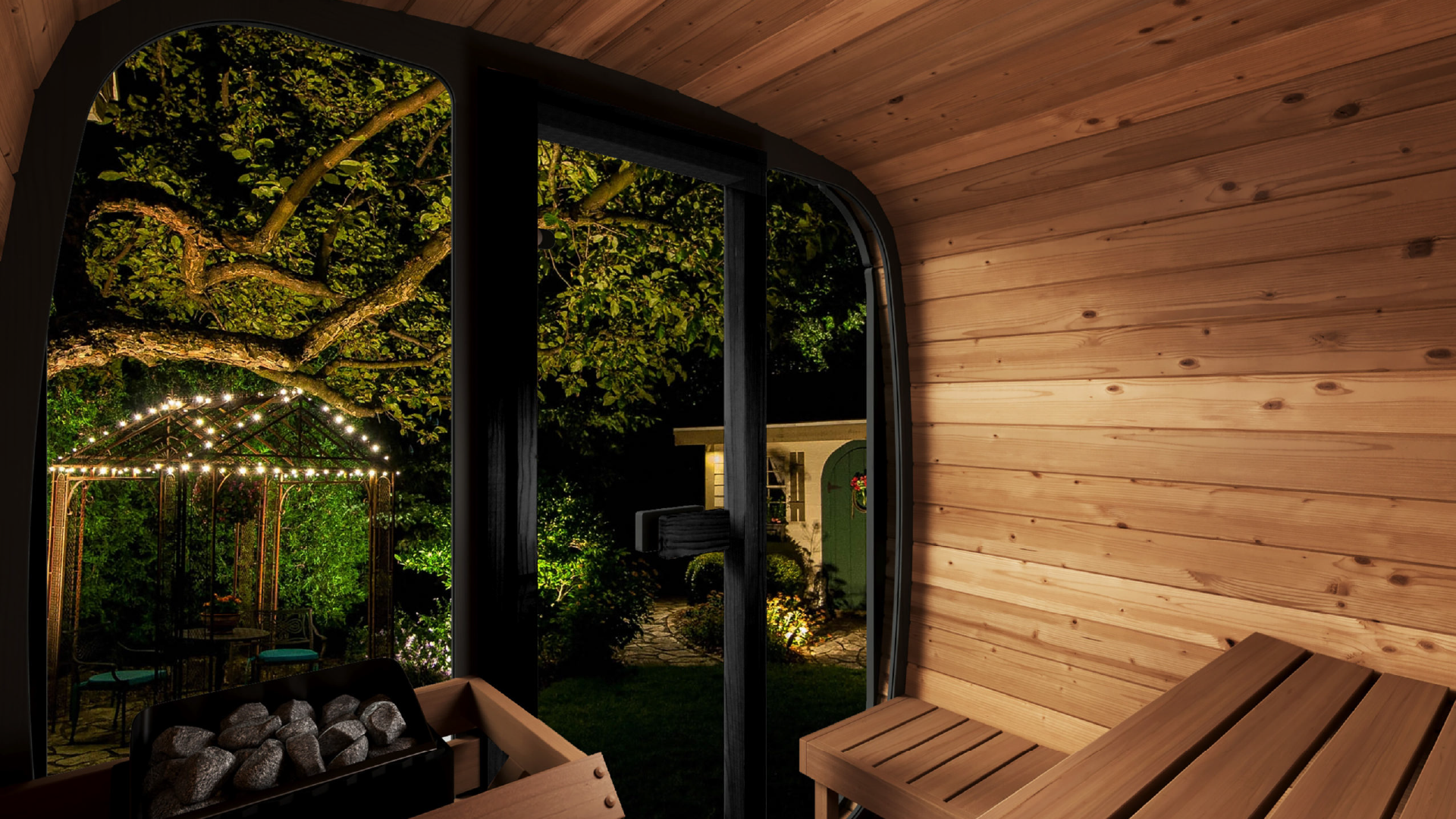 Wooden cabin interior with a view of a garden at night