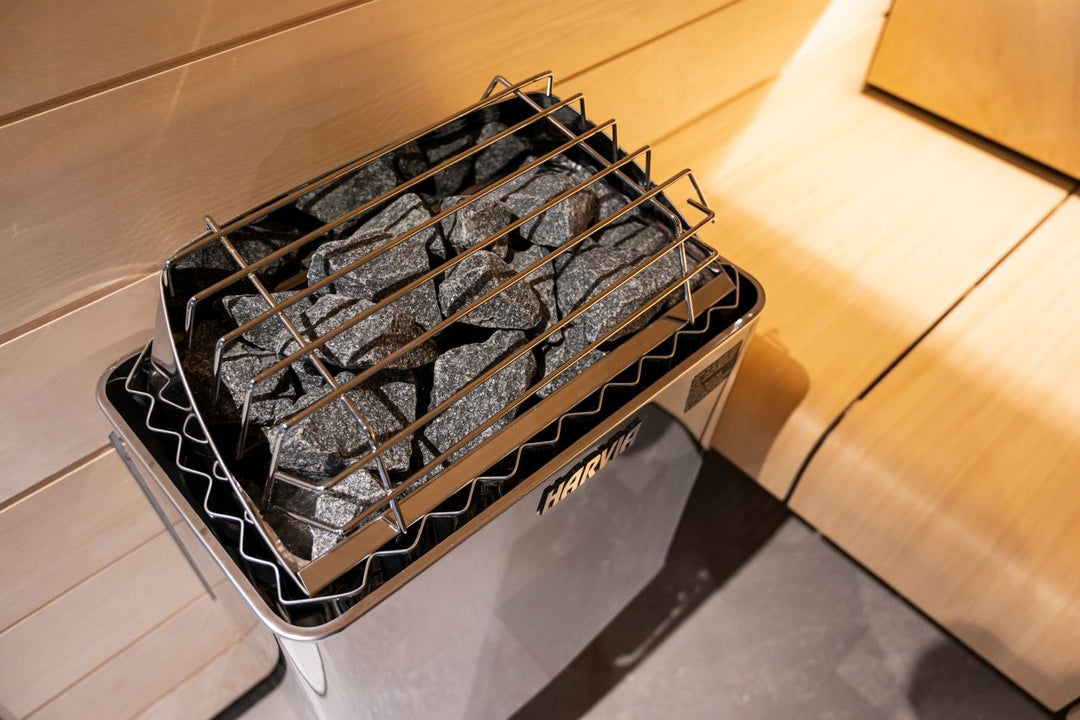 Harvia electric sauna heater with stones beside a light birch bench