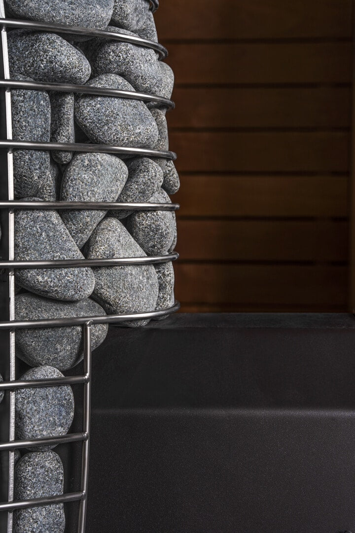 Decorative wall made of stacked stones with metal wire frame against a dark background