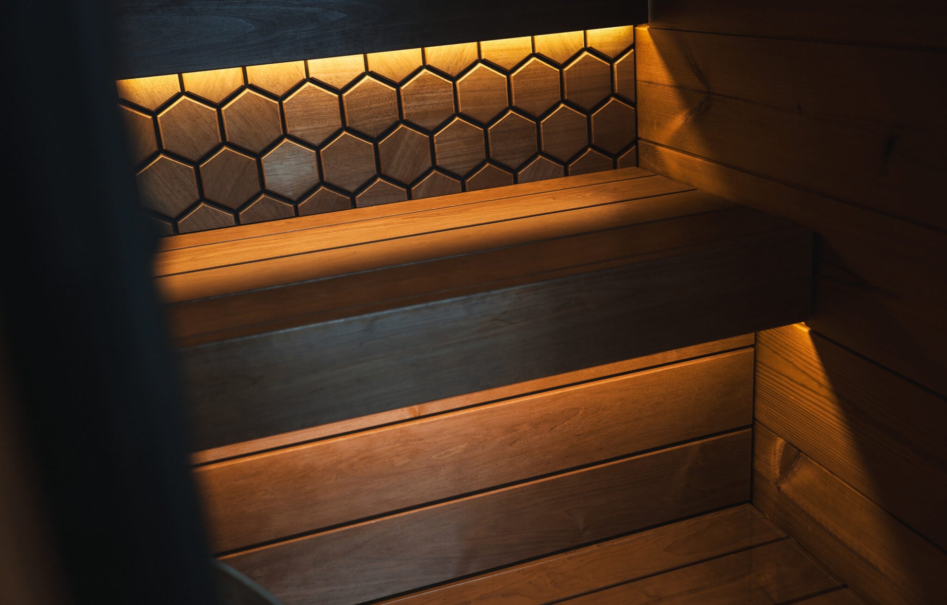 Wooden bench with hexagonal tile backrest in a dimly lit room